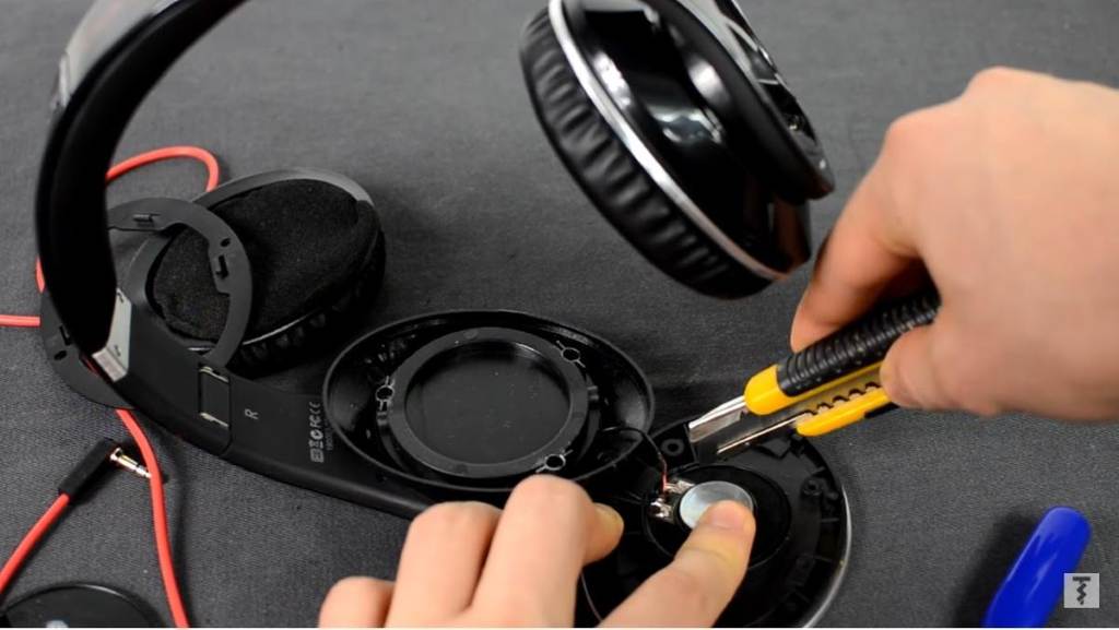 Broken plastic headphone yoke close-up showing cracks and damage